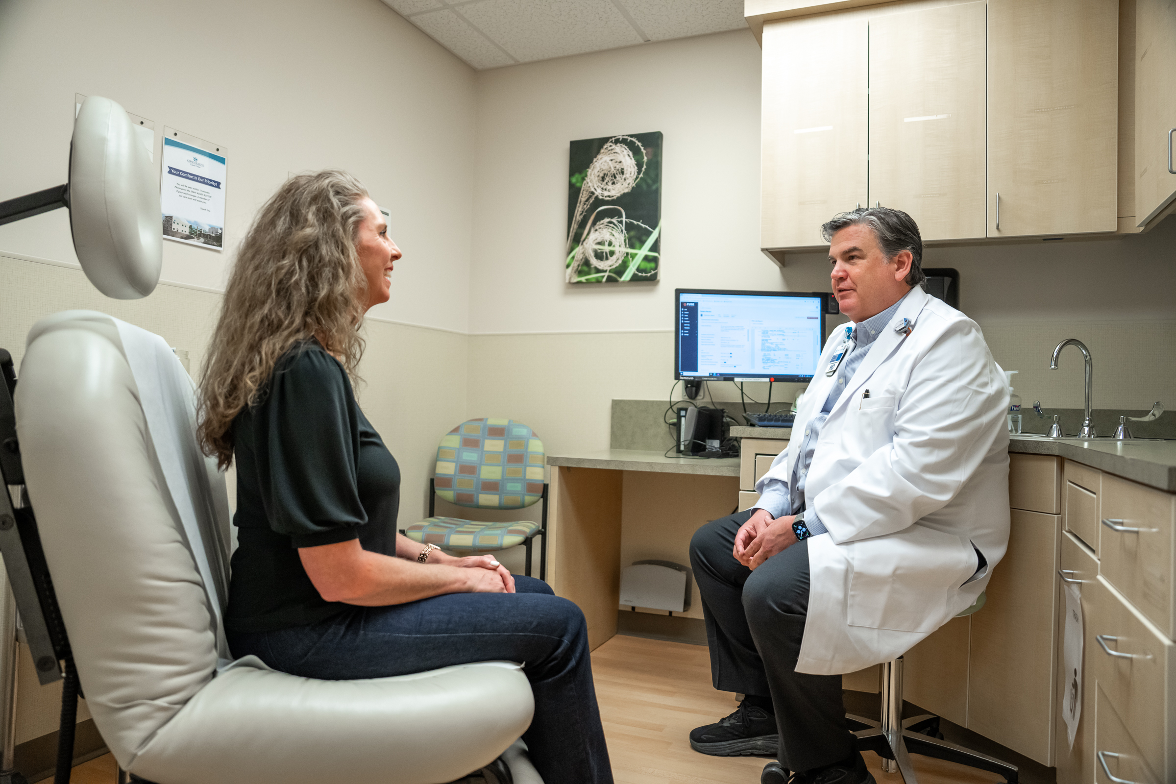 A clinician and patient talking in a consultation room